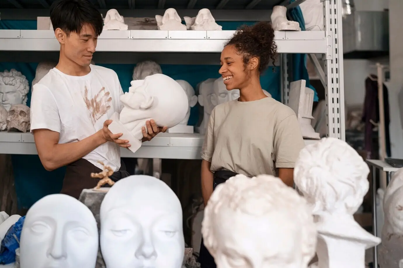 Vorderansicht von lächelnden Menschen mit Tonskulpturen